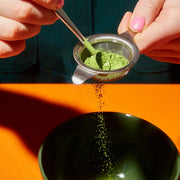 person sieving JENKI matcha into a bowl